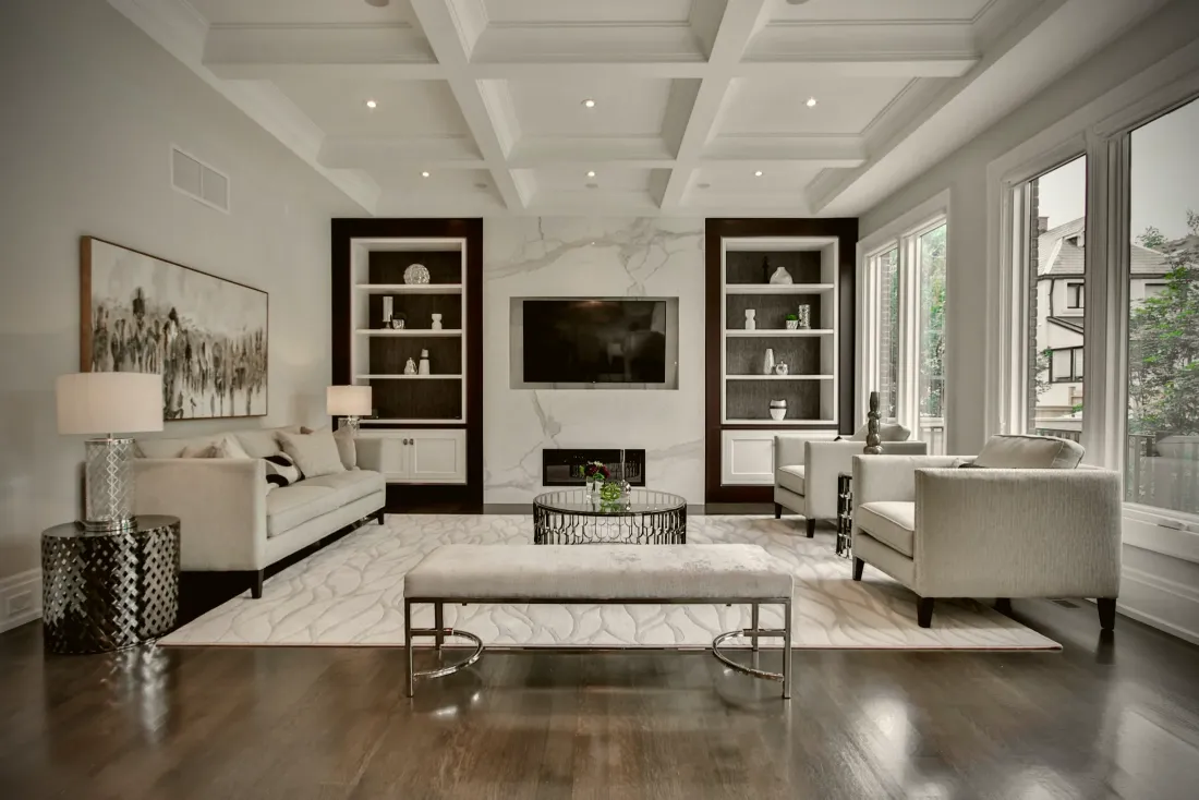 Living room with a coffered ceiling and built-in shelving