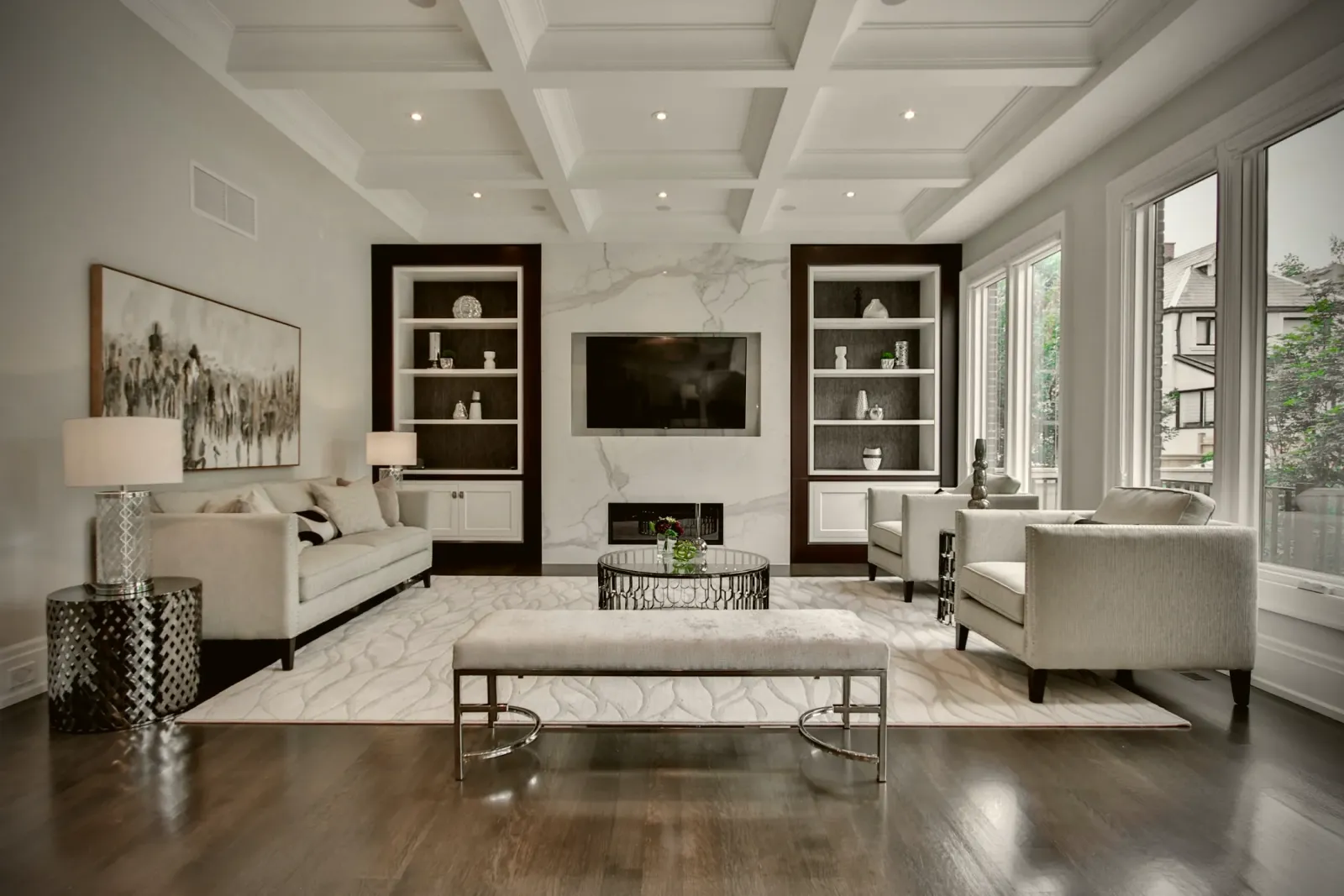 Living room with a coffered ceiling and built-in shelving