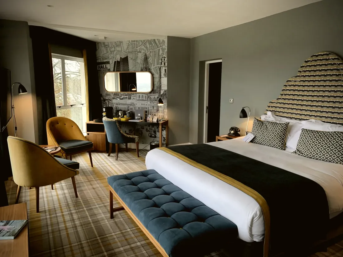 Bedroom with tailored curtains and an upholstered bench