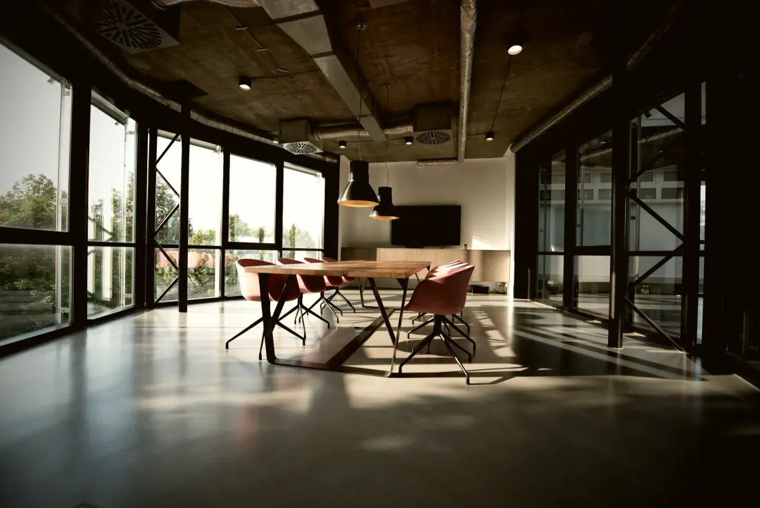 Open-plan office with a meeting table and glass partitions