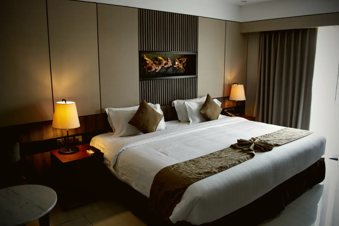 Bedroom with a padded headboard wall and warm lighting