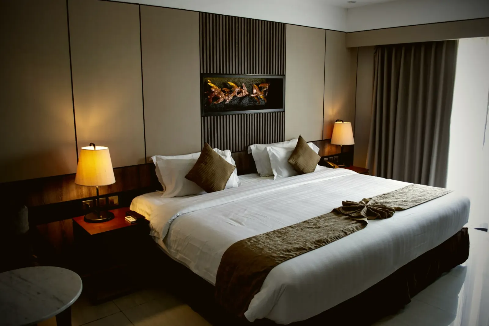 Bedroom with a padded headboard wall and warm lighting