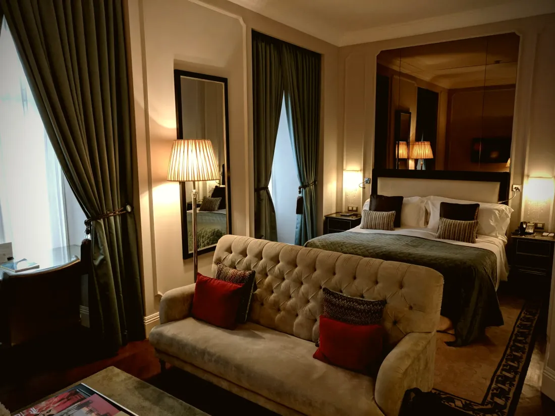 Bedroom with layered floor-length curtains and warm lamp light